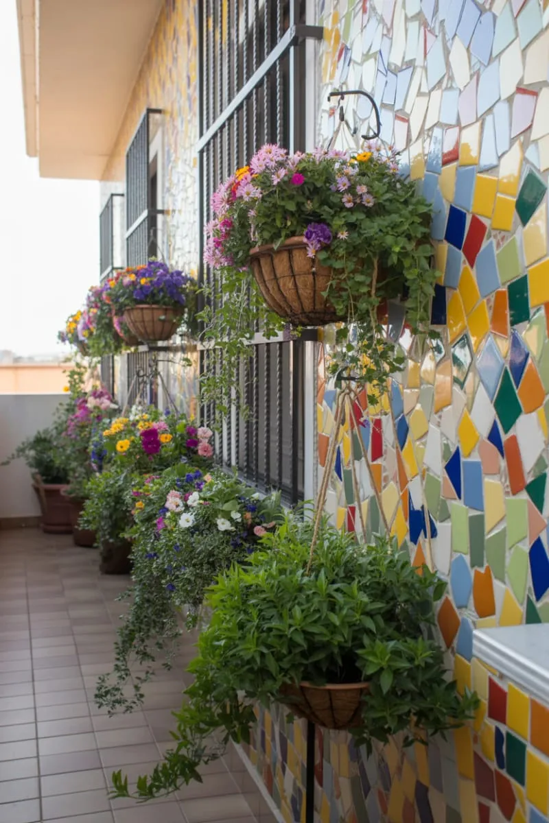 colorful mosaic wall with vibrant flowering hanging baskets 1