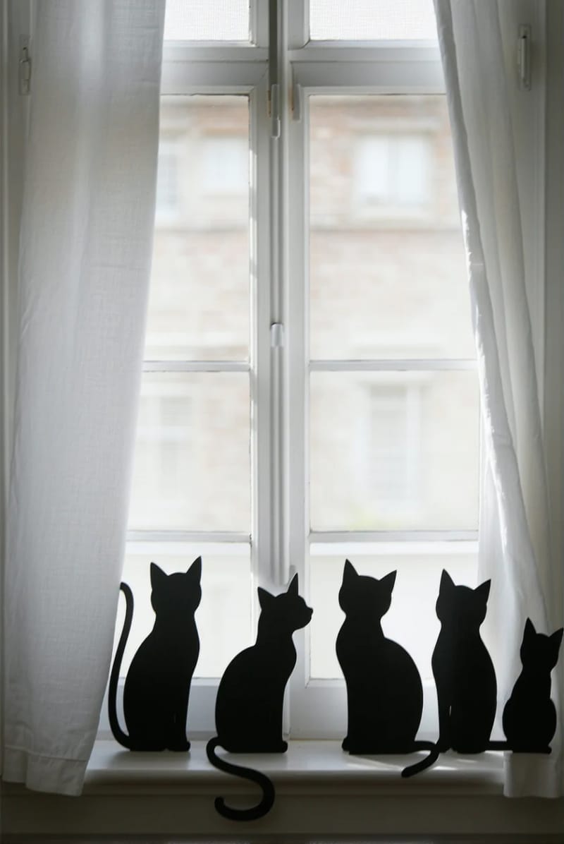21 Simple Halloween Decorations for an Easy Seasonal Touch 27 diy black cat silhouettes peeking from behind window curtains 1