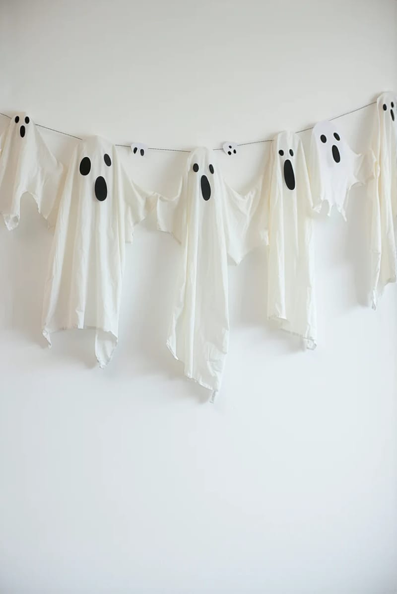 21 Simple Halloween Decorations for an Easy Seasonal Touch 3 floating ghost garland made from white fabric and black marker faces 1