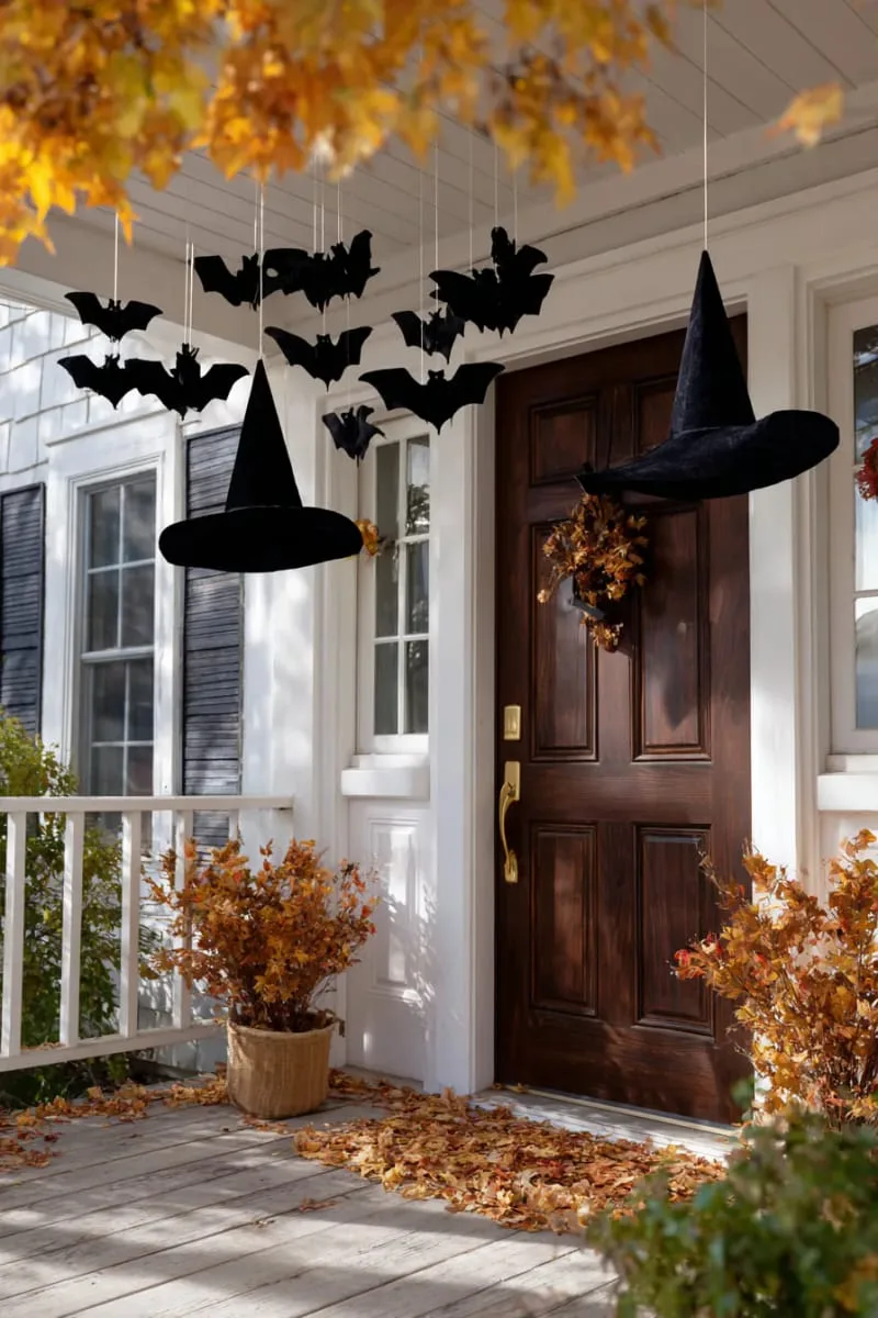 21 Creative Halloween Door Decorations: Ideas for a Festive Welcome 29 floating witch hats and bats swirling above the doorframe 1
