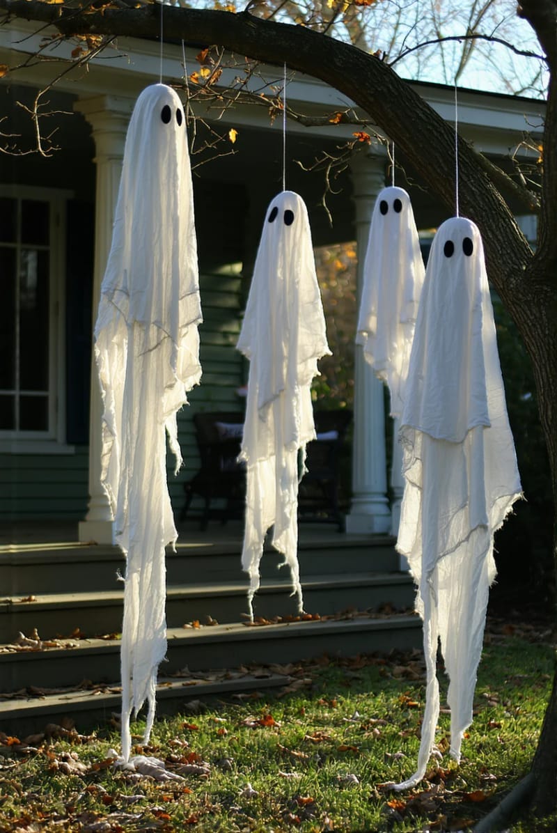 hanging cheesecloth ghosts swaying from porch trees 10