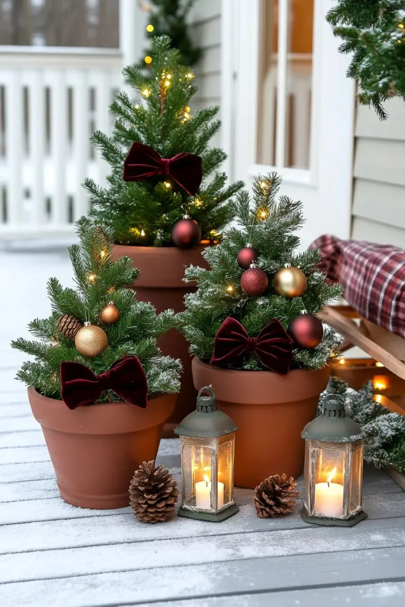 layered mini christmas trees in terracotta pots with velvet bows 1