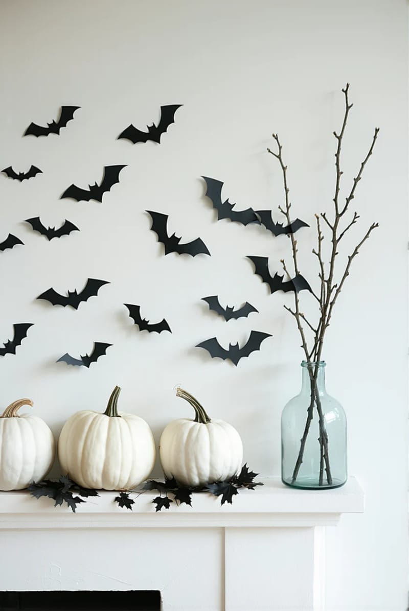 minimalist bat garland, white pumpkins, and a single branch in a vase 1