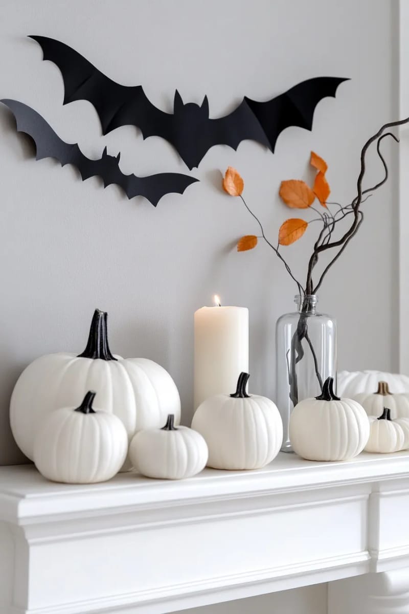 minimalist bat garland, white pumpkins, and a single branch in a vase 1