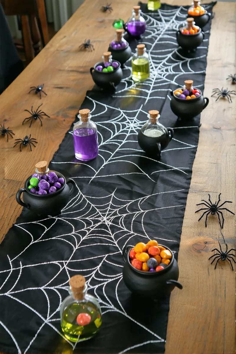 spider web table runner with mini cauldrons and potion jars 1