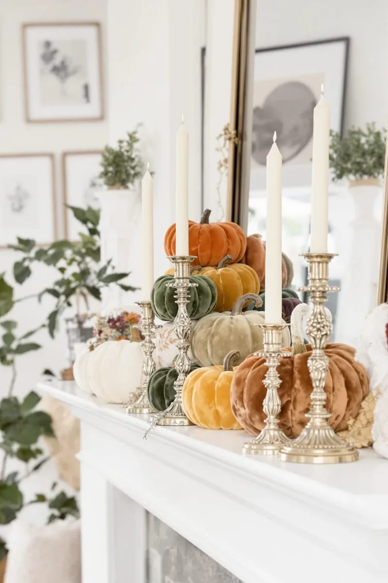 velvet pumpkin arrangement with antique brass candlesticks on the mantel 1