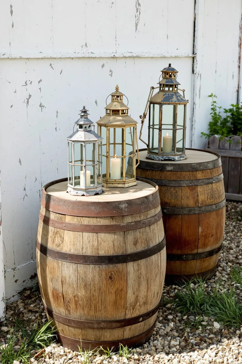 weathered lanterns clustered on wooden barrel tables 1