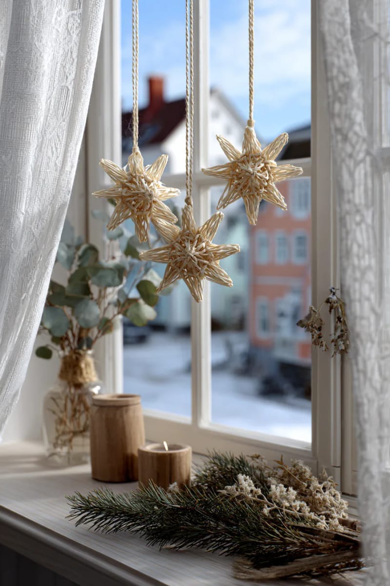 woven straw stars and bells hanging in the window 1
