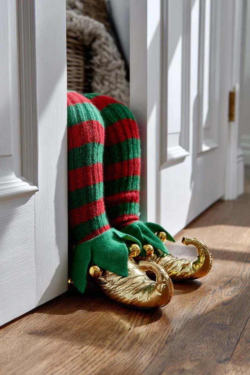 27 Stunning Christmas Decoration Crafts for a Unique 2025 34 elf legs peeking out from under the door for playful door decor 1