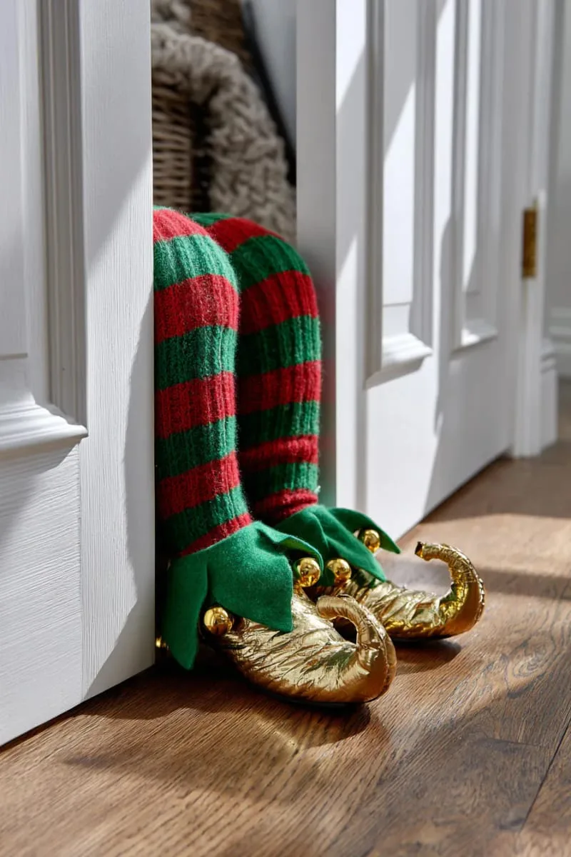 27 Stunning Christmas Decoration Crafts for a Unique 2025 33 elf legs peeking out from under the door for playful door decor 1