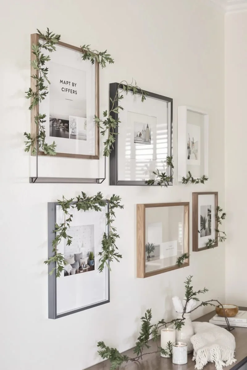 29 Simple Christmas Decor Ideas for a Beautiful Holiday Season 44 evergreen sprigs tucked into wall art or framed prints 1