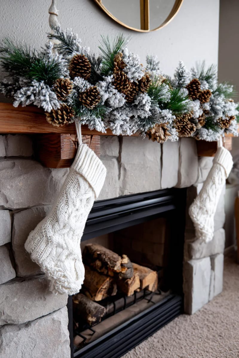fireplace with frosted garland, pinecones, and matching stockings 1