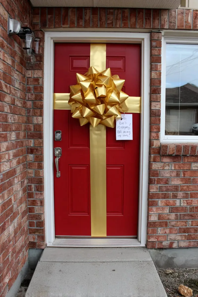 front door wrapped like a giant present with ribbon and tag 1