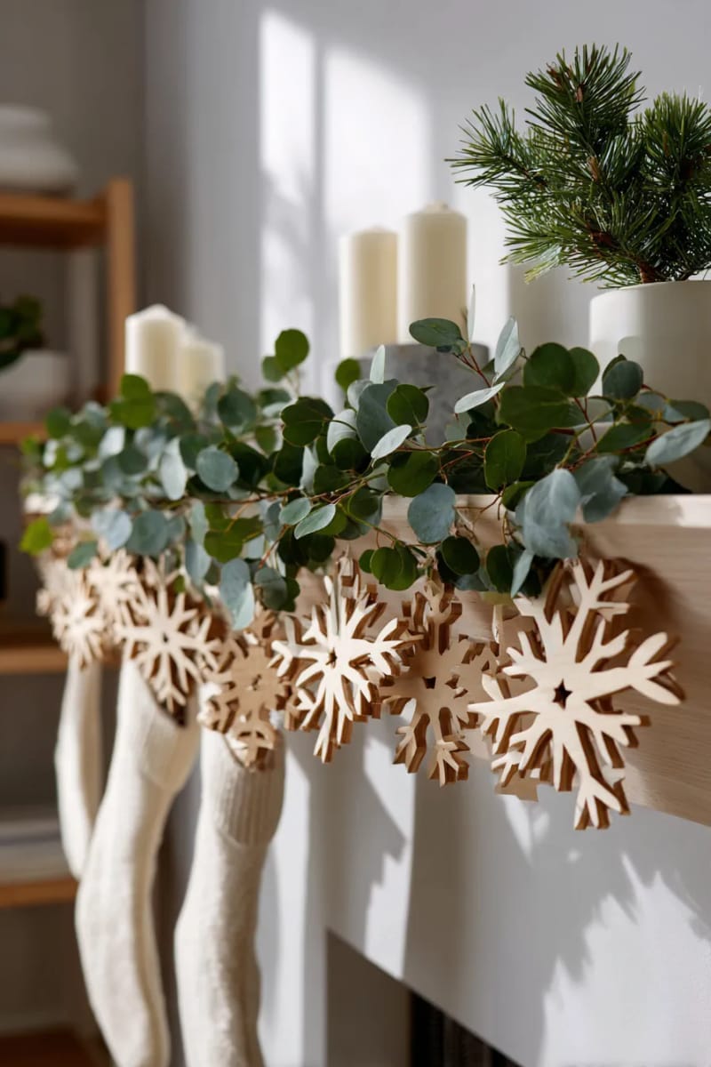 25 Best Christmas Window Decor Ideas to Try This Year 53 garland of wooden snowflakes accented with eucalyptus leaves for a neutral touch. 1