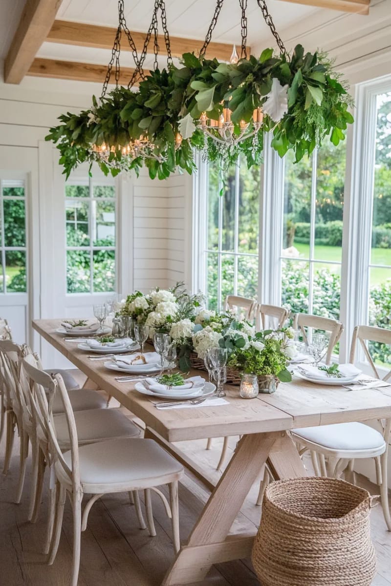 garland-wrapped chandeliers above a rustic wooden dining table 1