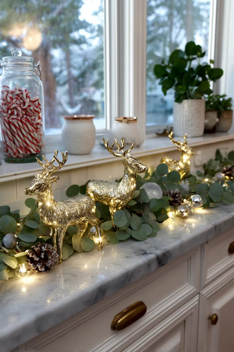 23 Christmas Countertop Decor Ideas Guests Can’t Stop Talking About 38 glittering gold reindeer figurines nestled among eucalyptus branches 1