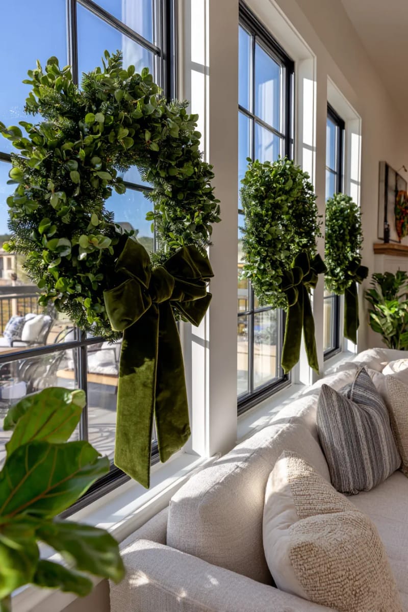 hang oversized wreaths adorned with velvet ribbons on living room windows 1