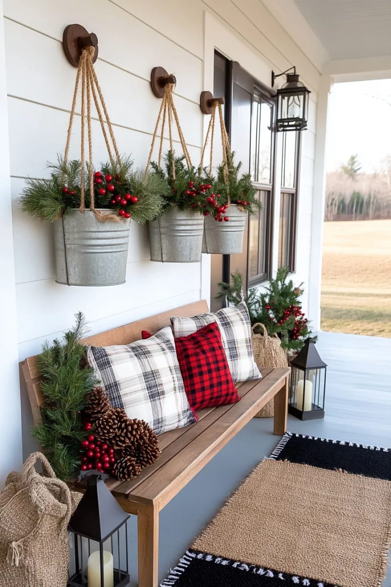 hanging galvanized buckets overflowing with evergreen branches and red berries 1