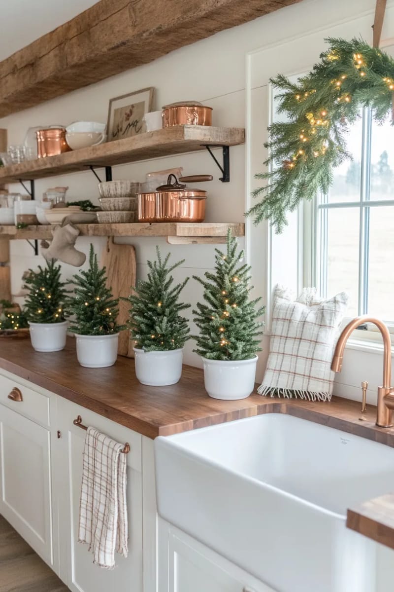 23 Christmas Countertop Decor Ideas Guests Can’t Stop Talking About 3 mini pine trees in white ceramic pots lined along the kitchen countertop 1