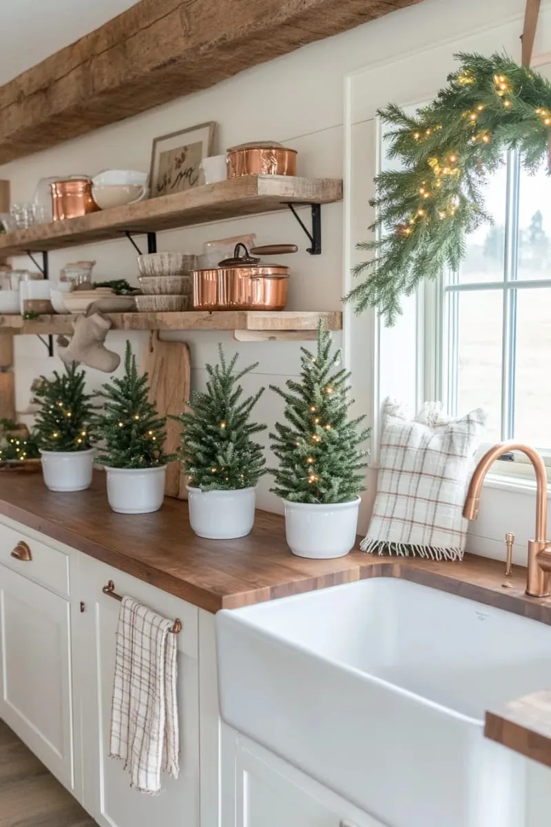 23 Christmas Countertop Decor Ideas Guests Can’t Stop Talking About 7 mini pine trees in white ceramic pots lined along the kitchen countertop 1