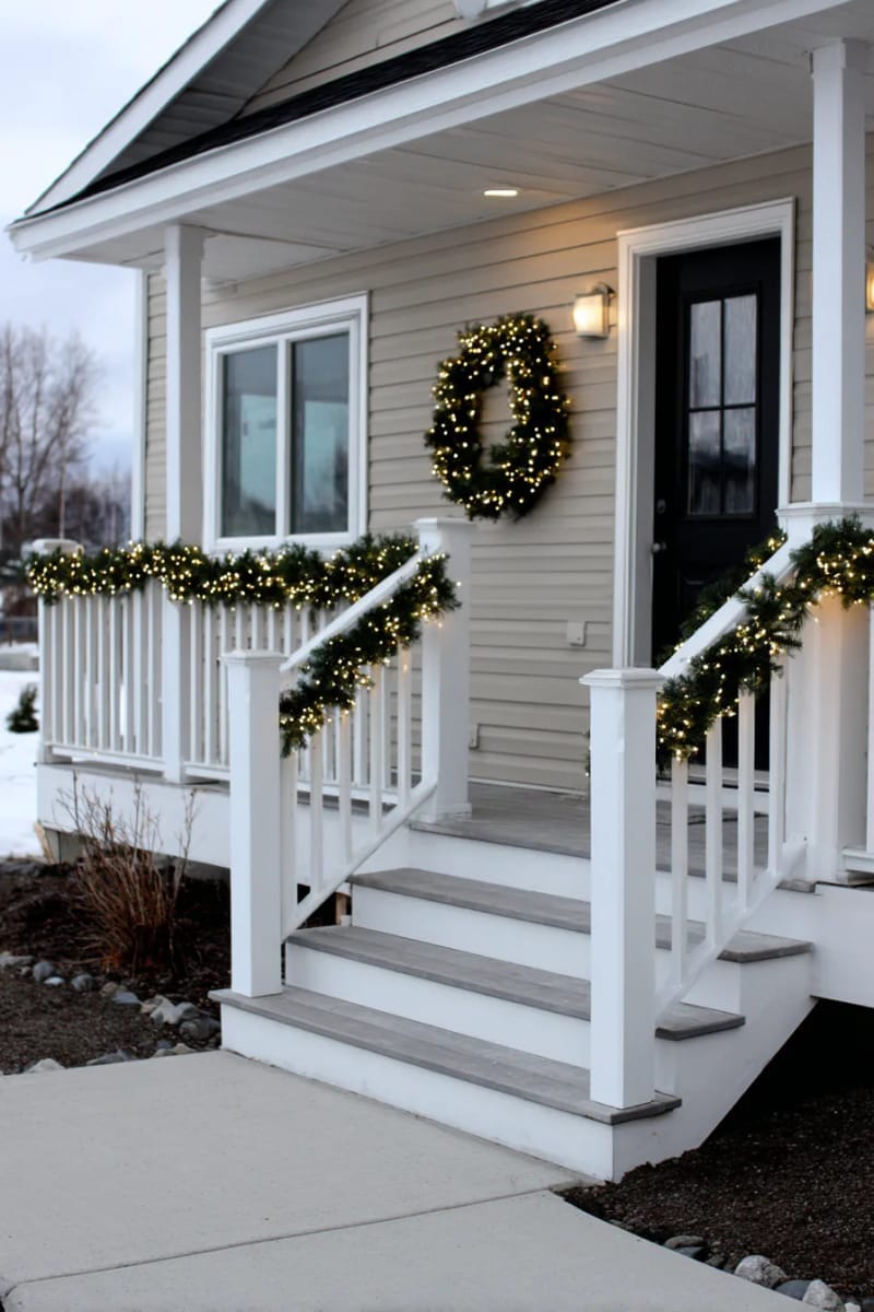 minimalist porch with delicate micro-lights and a single illuminated wreath 1