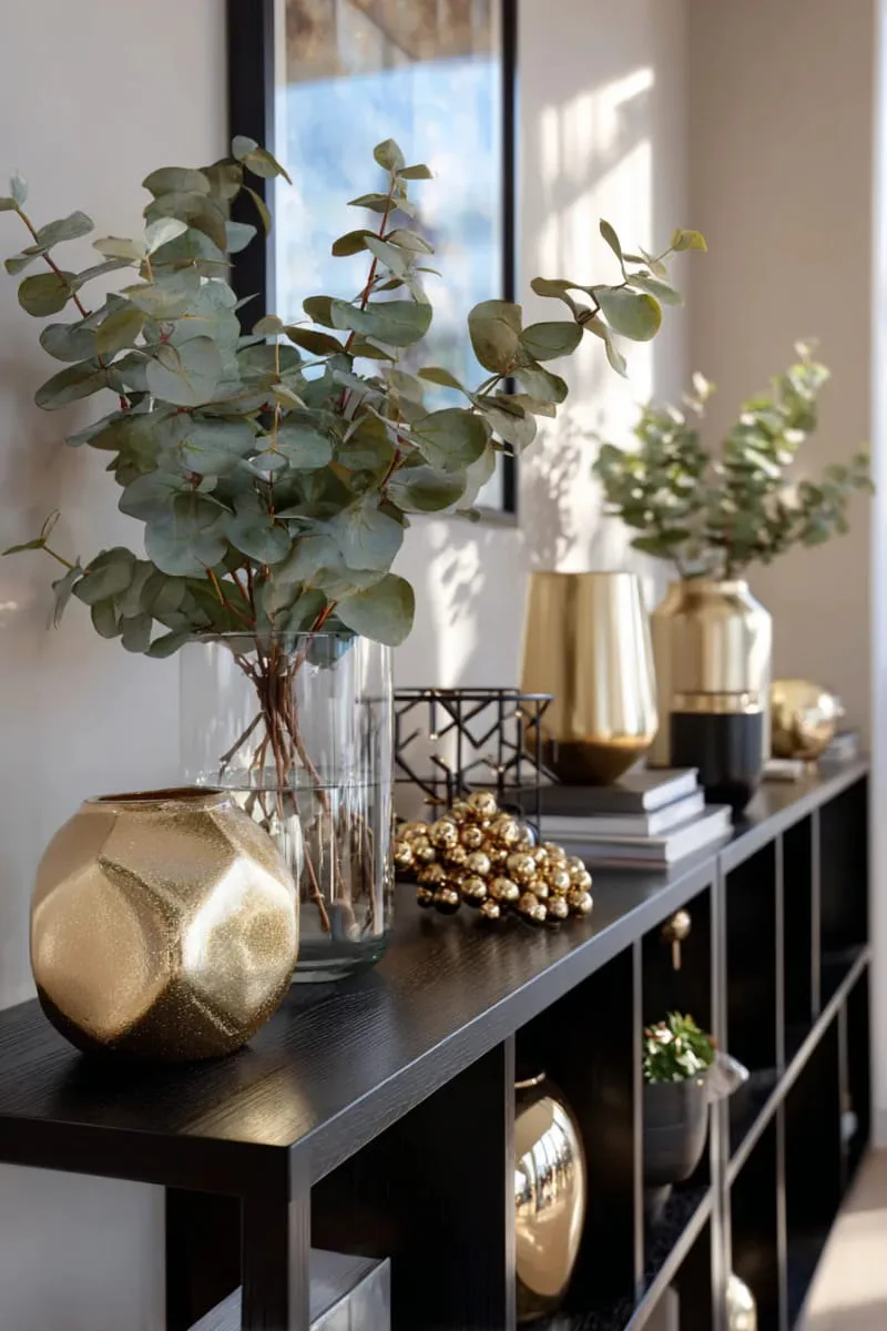 modern black shelving with gold ornaments and eucalyptus sprigs 1