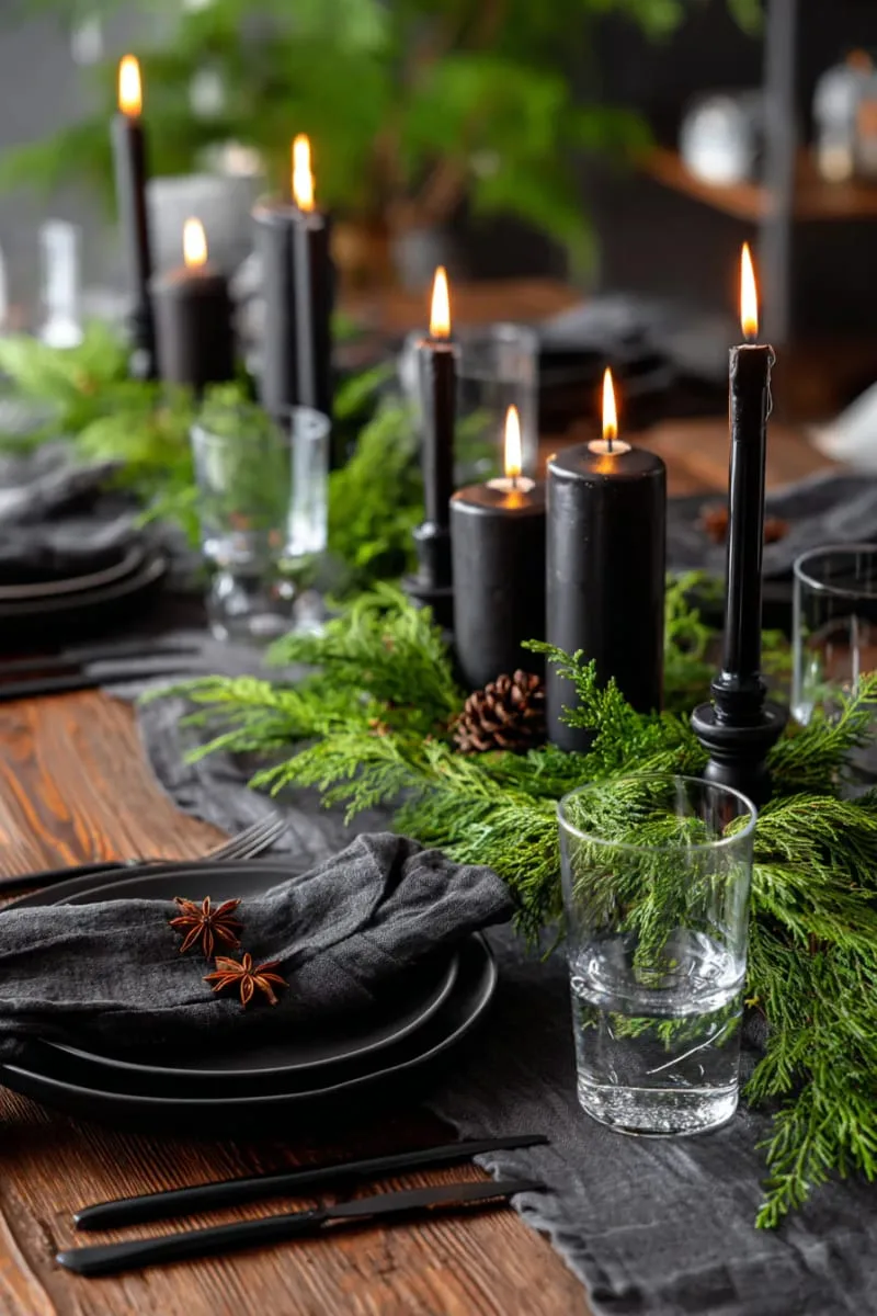 moody winter tablescape with black candles and cedar sprigs 1