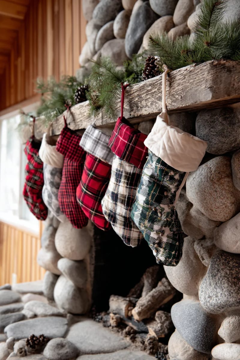 oversized plaid stockings hanging from a rustic stone mantle 1