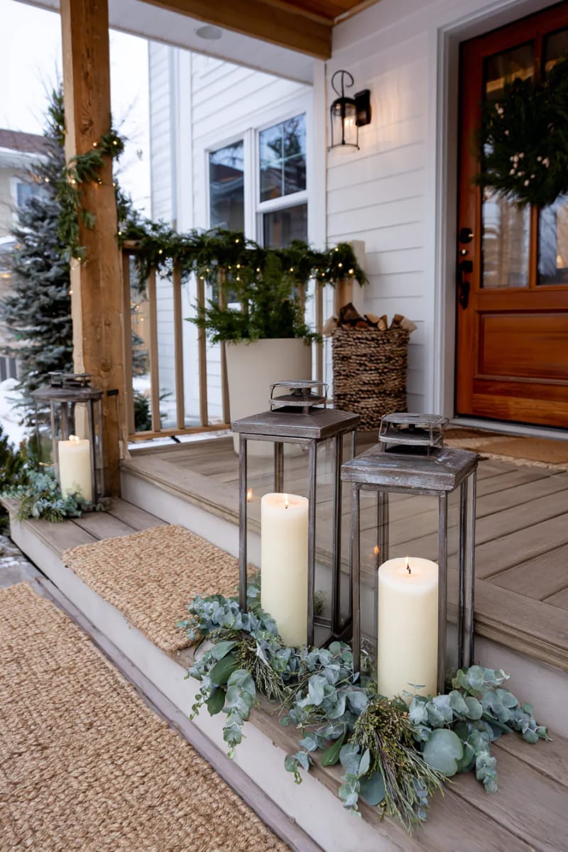 oversized rustic lanterns with pillar candles and eucalyptus sprigs beside the door 1