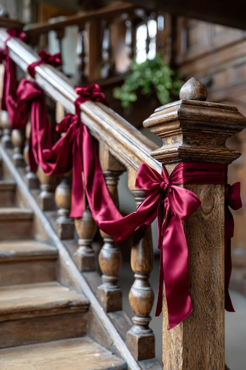 scarlet ribbon garlands draping across vintage wooden stair railings 1