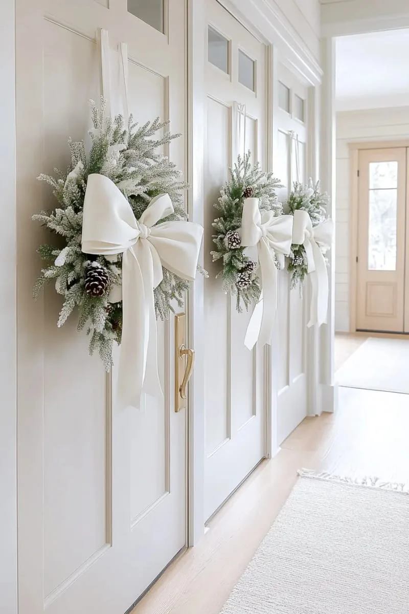 25 New Gorgeous White Christmas Decor Ideas That Wow 55 snow-dusted wreaths with white velvet bows on interior doors or windows 1