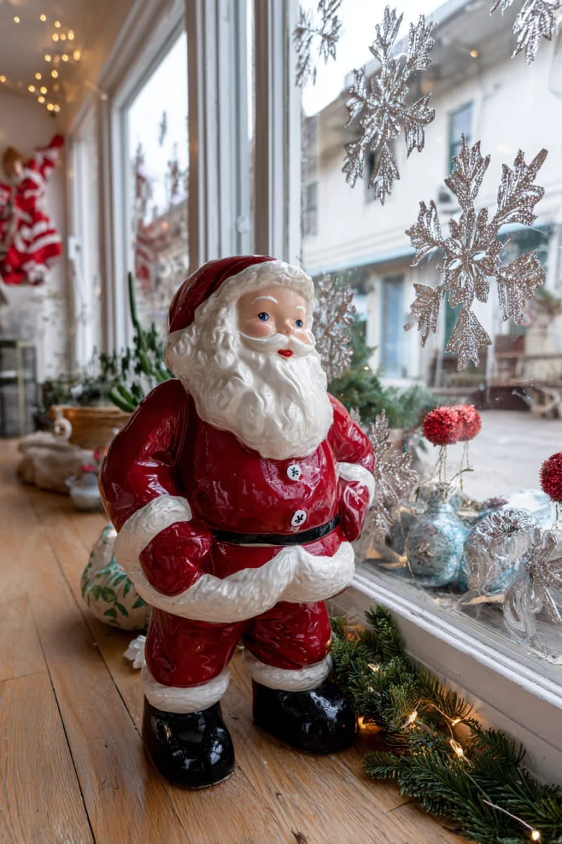 23 Kitsch Christmas Decor Ideas Full of Color, Whimsy, and Cheer 24 vintage blow mold santa paired with glittery snowflake window clings 1