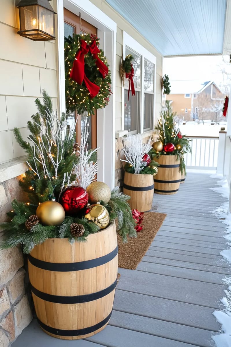 barrel planters overflowing with cedar, birch branches, and giant christmas ornaments 1