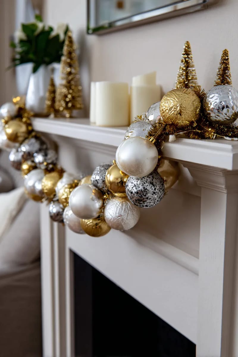 create a gold and silver ornament garland draped across a neutral mantel. 1