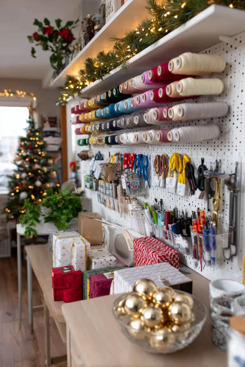 fairy lights woven through a pegboard filled with colorful sewing supplies 1