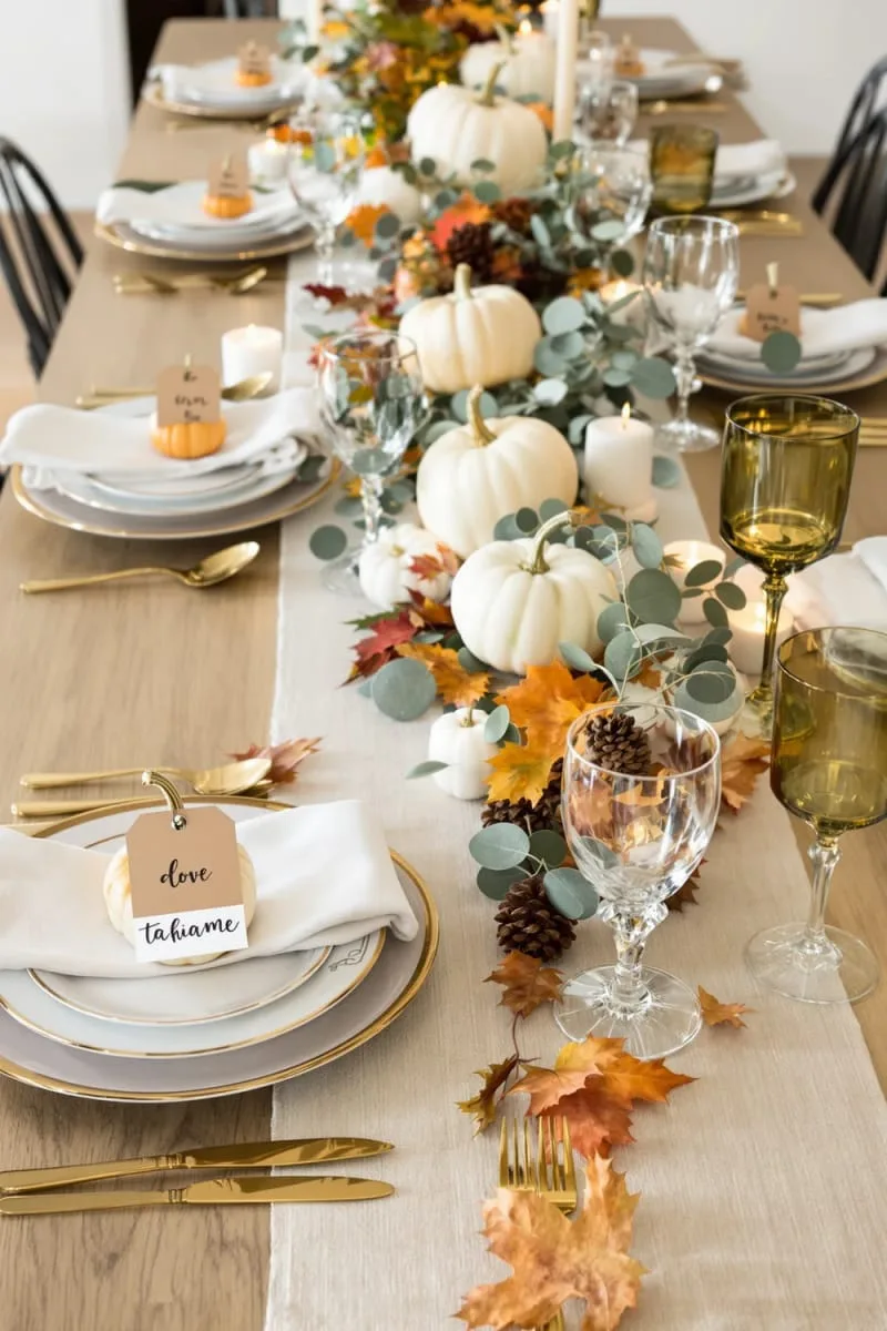 mini pumpkin place cards with handwritten names at each dinner setting 1