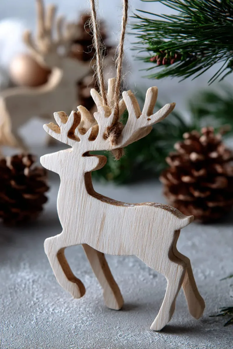 minimalist laser-cut reindeer silhouette ornament in natural wood finish 1