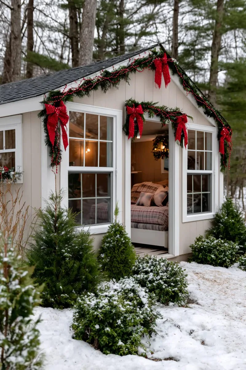 15 She Shed Christmas Decor Ideas For A Unique Winter Wonderland 26 red ribbon bows and cranberry string garlands along the roof edge 1