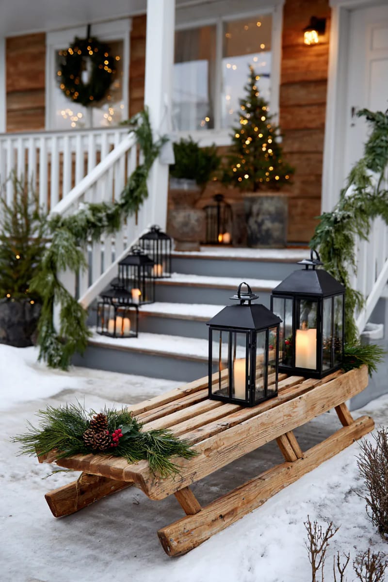 rustic wooden sled by the front steps topped with lanterns and holly 1