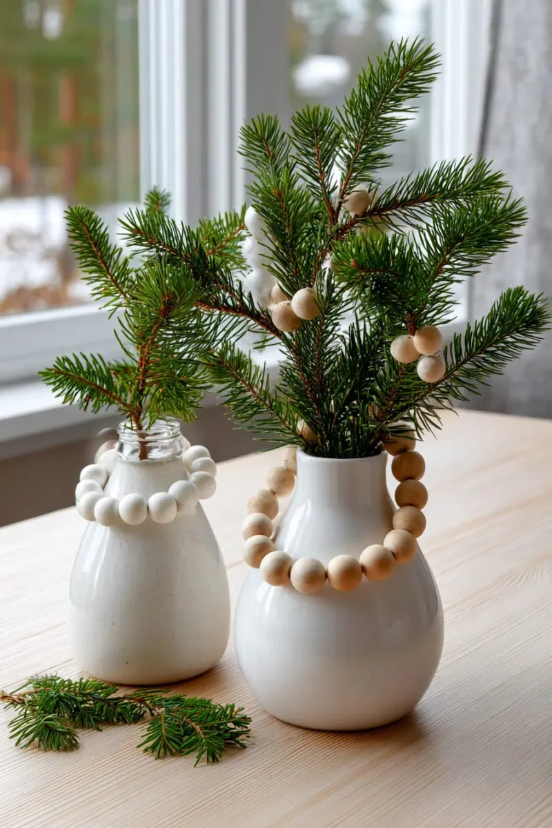wooden bead garlands draped over pine branches in simple scandinavian vases 1