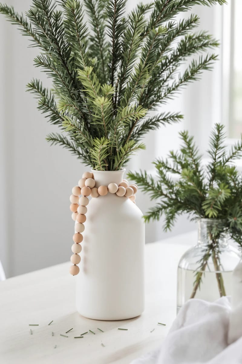 21 Scandinavian Christmas Decorations Ideas To Bring Nordic Charm at Home 6 wooden bead garlands draped over pine branches in simple scandinavian vases 1