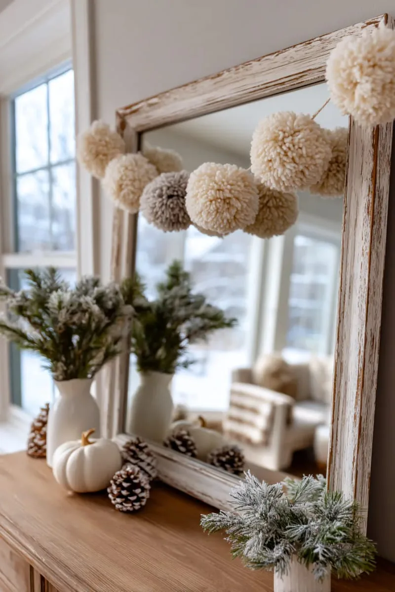 neutral pom-pom garland draped across a vintage mirror 1