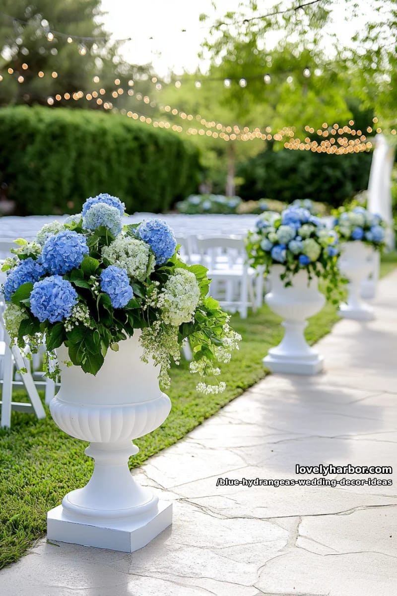 modern white urns overflowing with blue hydrangeas and greenery 1