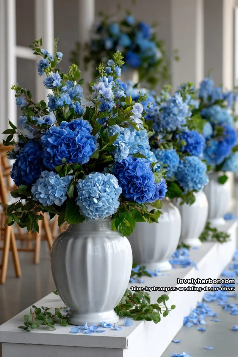 modern white urns overflowing with blue hydrangeas and greenery 1