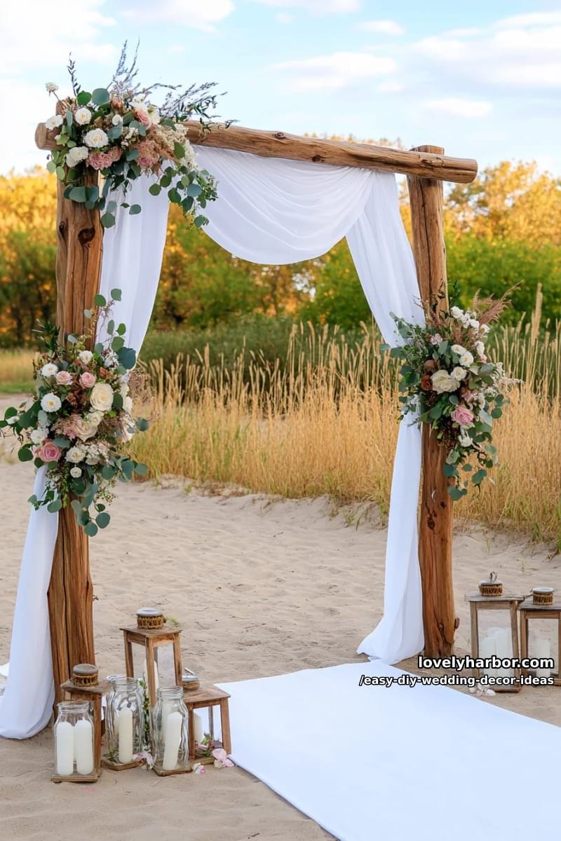simple driftwood wedding arch decorated with eucalyptus and wildflowers 1
