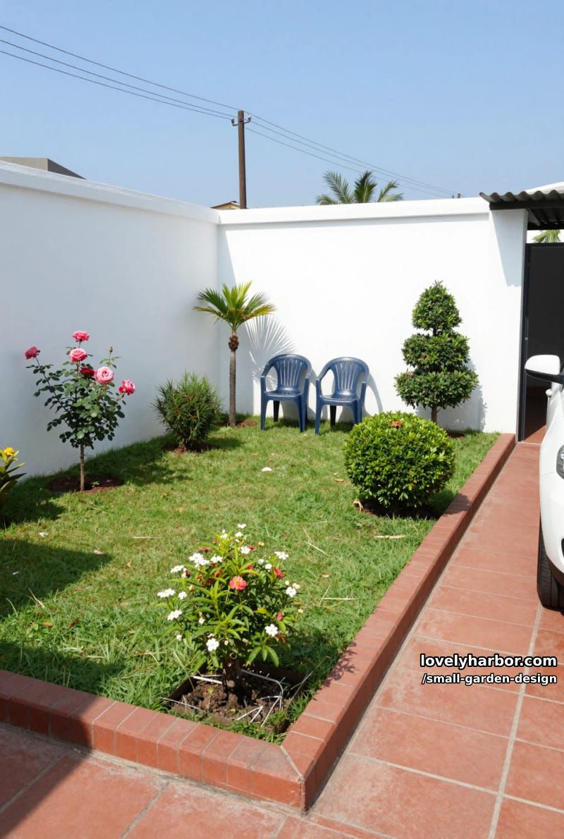 small enclosed garden with lawn, brick border, flowering plants, and stacked chairs. 1