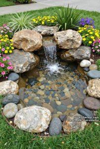small garden pond with cascading waterfall and vibrant flowering plants. 2