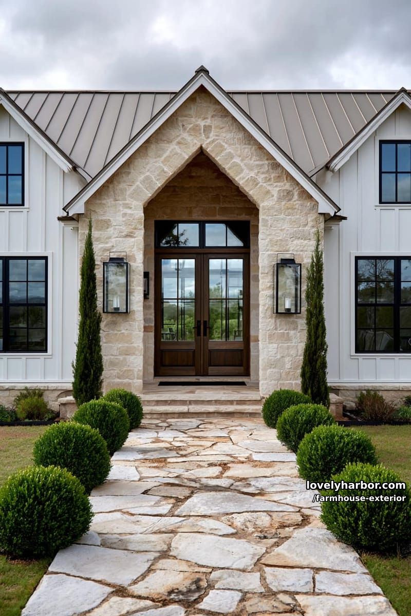 modern farmhouse, stone entry, white siding, metal roof, flagstone path, boxwood shrubs. 1