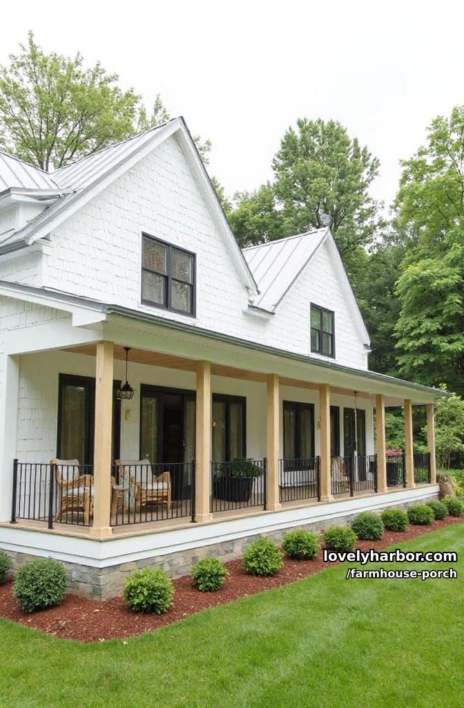 modern farmhouse with black railing, wicker chairs, wood posts, and potted shrub. 1