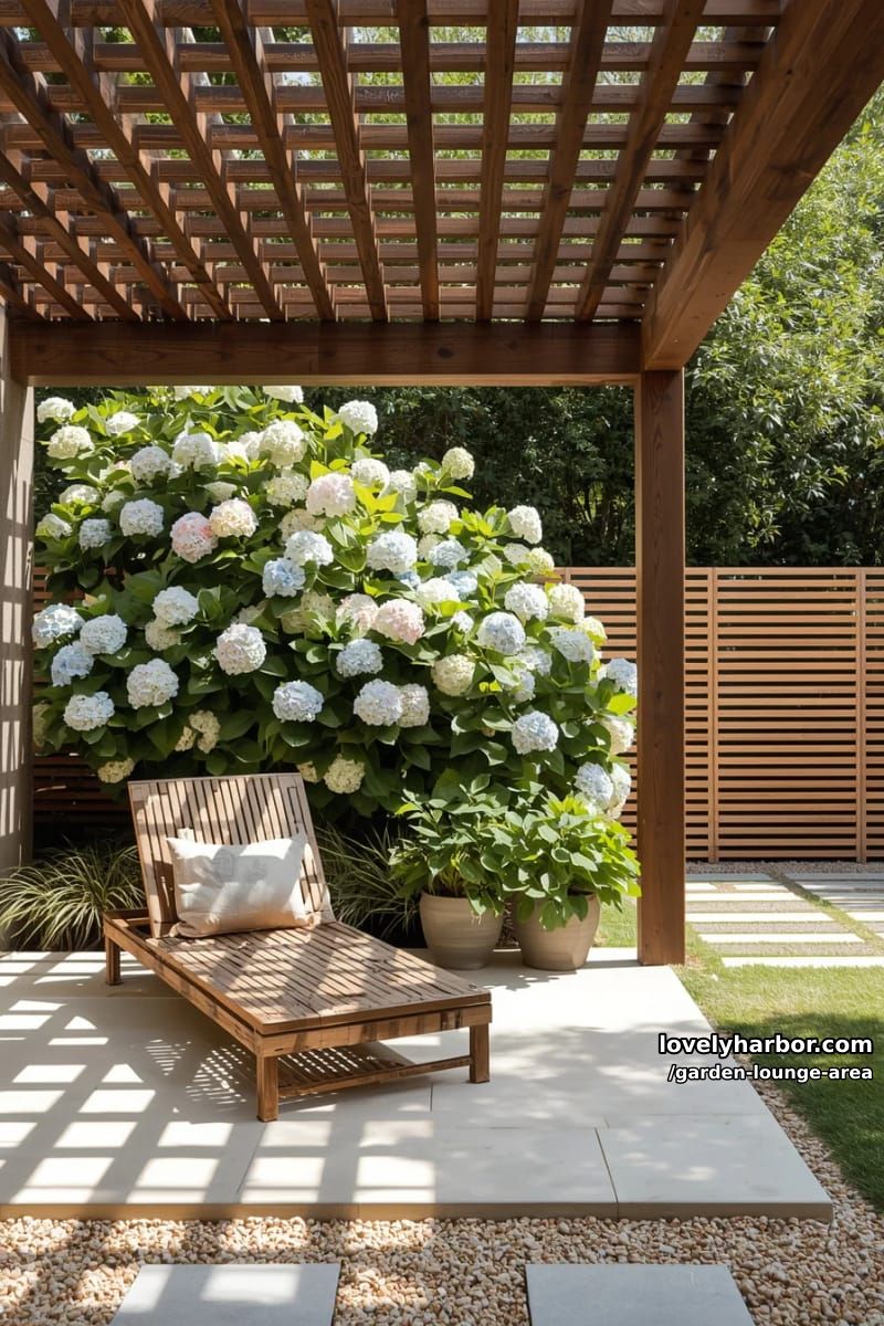 slatted lounge chair under pergola with hydrangeas and privacy screen 1